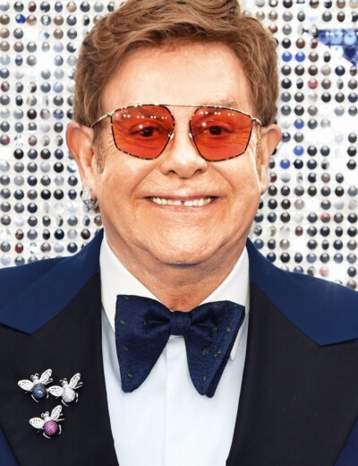 Proč je Sir Elton na vozíku a v roušce?